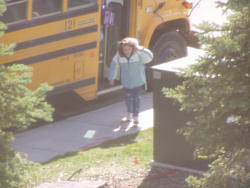 Ребенка возвращается домой - выходит из школьного автобуса.